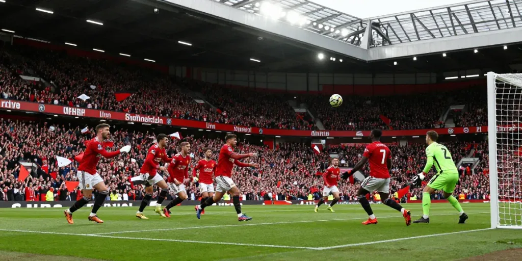 Dynamic match scene of แมนฯยูไนเต็ด vs ลิเวอร์พูล showcasing fans and players in action.